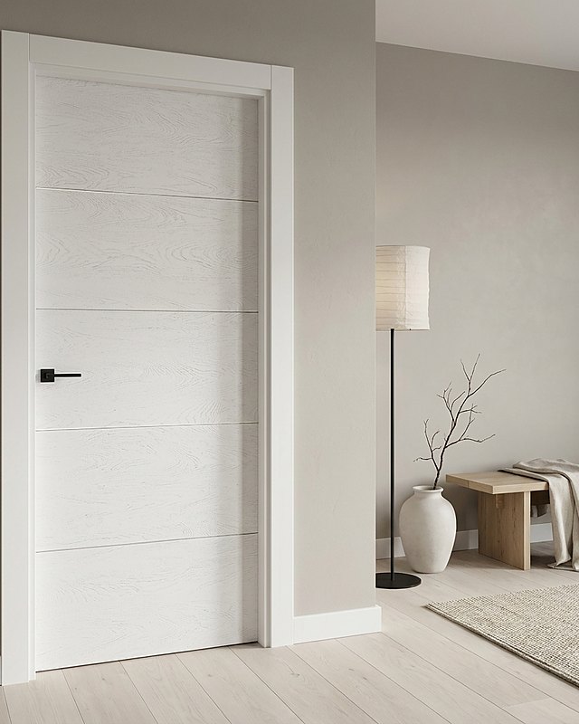 Puerta lacada blanca a poro abierto con cuatro ranuras horizontales y manilla negra, pared gris cálido. Imagen ilustrativa.