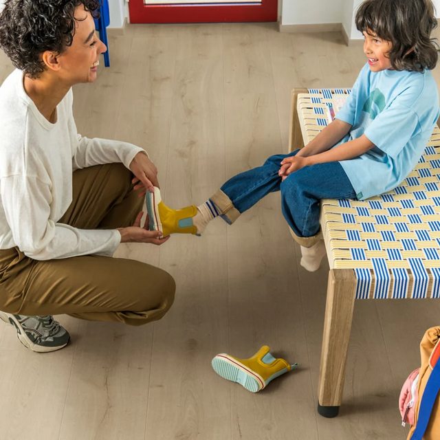 Familia en un salón con laminado Quick-Step Majestic de lama extralarga